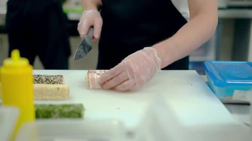 Cook Cuts a Japanese Roll with Bacon.