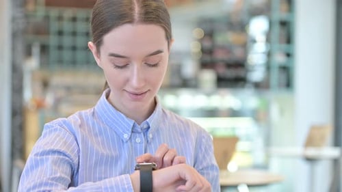 Young Woman Using Smartwatch in Modern Workplace