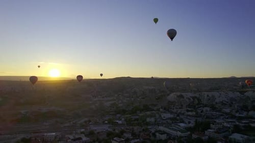 Hot Air Balloons Fly Over City at Sunrise