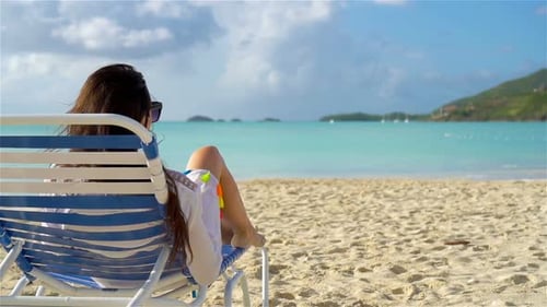Woman Sunbathing on a Lounger at Tropical White Beach