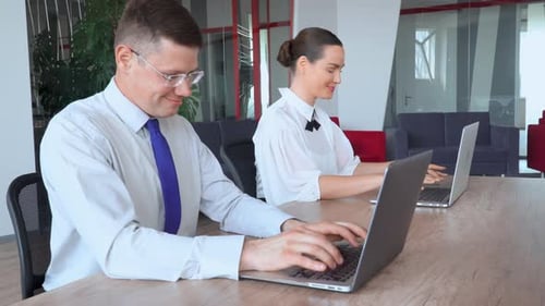 Focused Candid Managers Typing on Computers