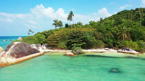 Limestone cliffs caved by shallow water of turquoise lagoon on beautiful shore of tropical island wi