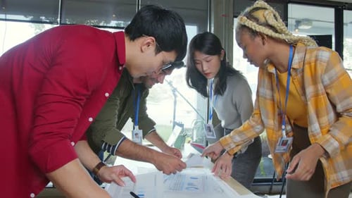 Diverse Team Collaborating on Project in Modern Office