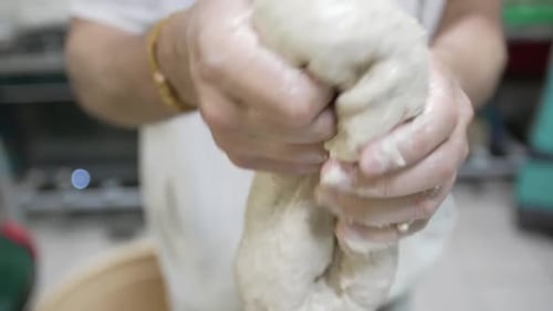 Person Kneading Bread Dough in Bright Setting