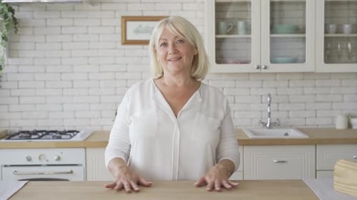 Smiling Woman Standing in a Bright Kitchen
