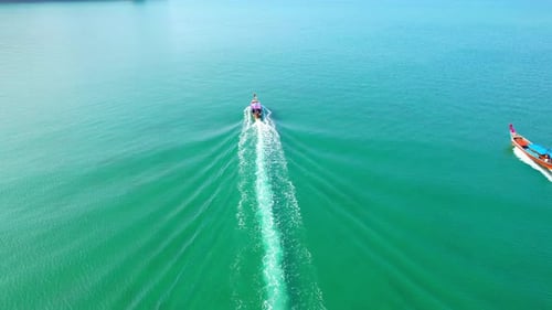 An aerial view of the boat sailing in the beautiful turquoise waters