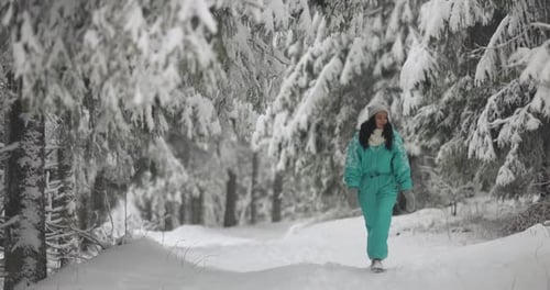 Woman in Ski Suit in Snowy Forest During Winter Vacations Outdoors