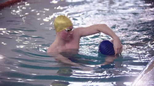 Swimming Instructor Teaching a Kid How to Swim Underwater in the Pool