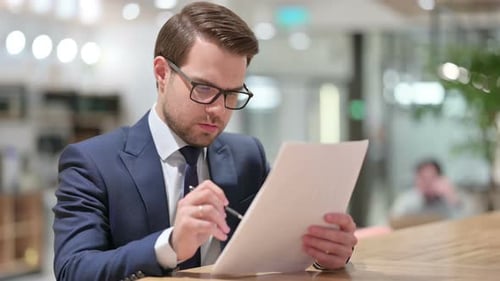 Man Signing Documents in Modern Office Close Up