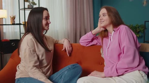 Two Young Women Chatting on a Couch