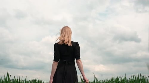 Flamboyant Girl In Black Dress Goes By The Field.