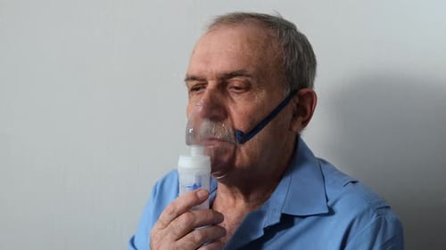 Un homme âgé fait un nébuliseur de thérapie par inhalation