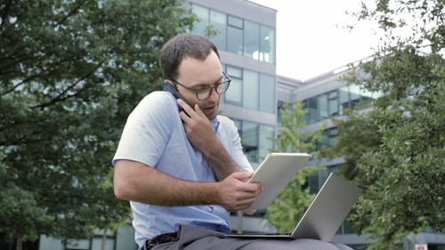 Busy Man Working on Laptop and Phone Outside
