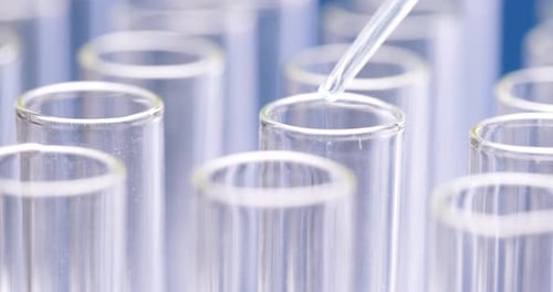 Dropping Liquid into Test Tube in Laboratory