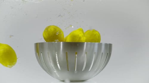 Lemons Floating in Water with Silver Bowl