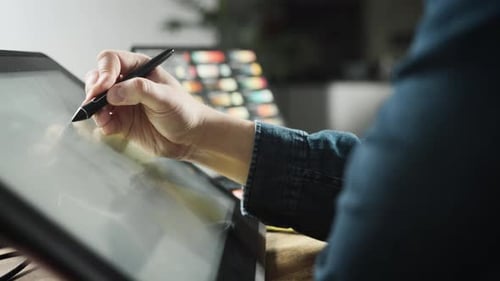 Digital Artist Drawing on Tablet in Workplace