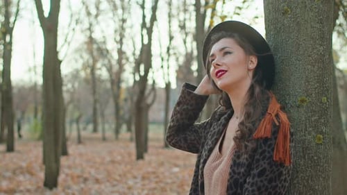 Happy Playful Woman in Coat Hat and Scarf in Autumn Park