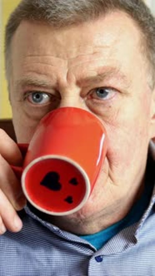 Senior Man Drinking from Coffee Mug Close Up
