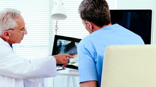 Male doctor discussing x-ray report with a patient
