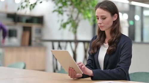 Woman Using Tablet at Desk in Modern Office