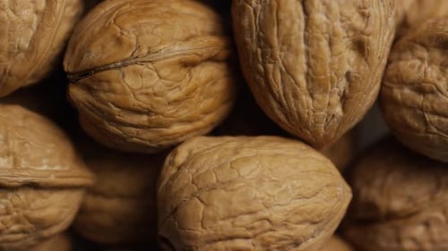 Cinématographique et rotatif de noix dans leur coquille sur une surface blanche - WALNUTS