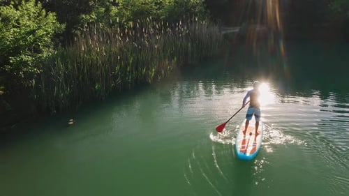 Man Paddleboarding on Emerald Lake from Above