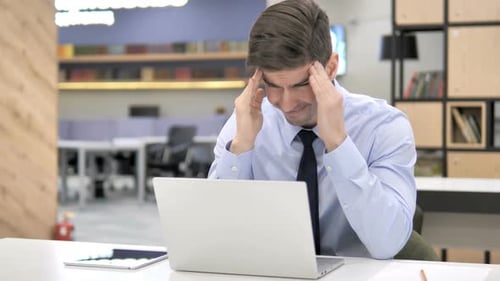 Frustrated Man Working On Laptop With Headache