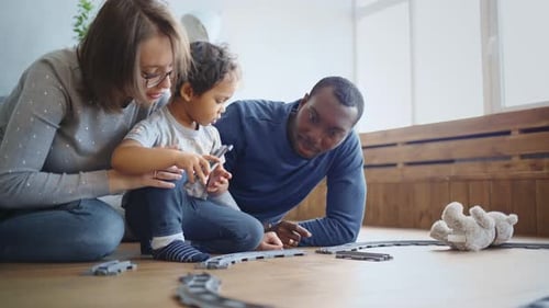 Family Assembling Toy Train Set Together Indoors