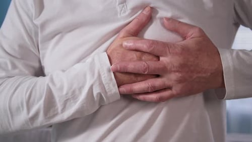 Close Up Pensioner Holding His Chest with Both Hands Old Man Suffering From Heartache
