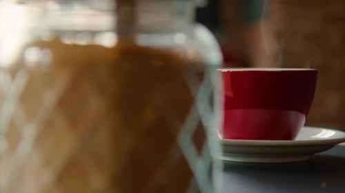 Red Cup of Steaming Hot Coffee on Table in Cafe