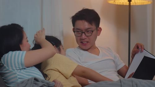 Loving Family Reading Together in Bed at Night