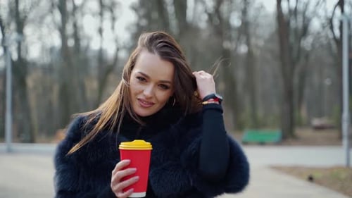 Beautiful woman with a plastic cup outdoors