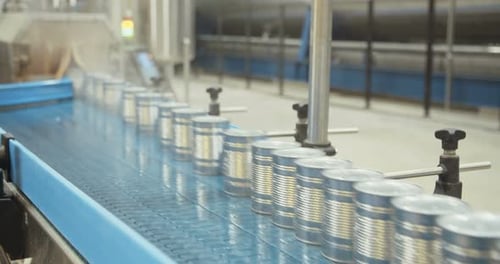 Silver Cans Moving on Conveyor Belt in Factory