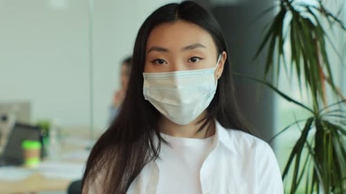 Woman Wearing Mask in Modern Office Setting
