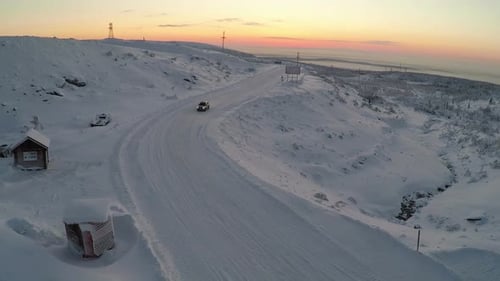 Aerial view of car driving snowy road and drifting