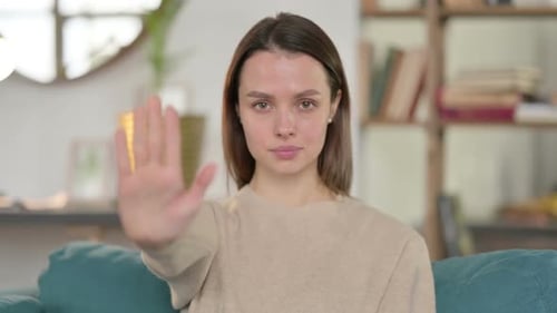 Portrait of Young Woman with Stop Sign By Hand