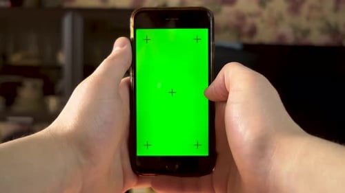 Der Mann benutzt das Telefon. Mit der Hand wischen Sie auf dem Smartphone mit grünem Bildschirm nach rechts. Chroma-Schlüssel.