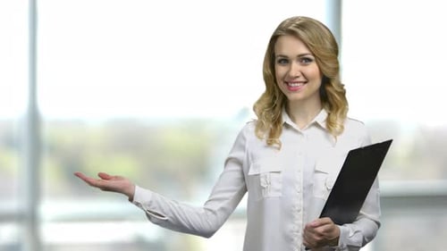 Smiling Woman Holding Clipboard Presenting Product