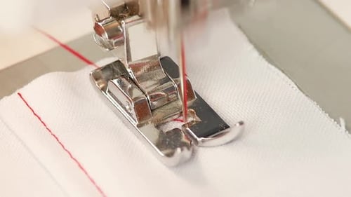 Sewing Machine Stitching White Fabric with Red Thread