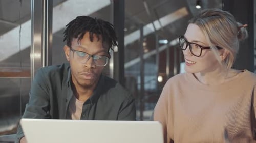 Team Discussing Project on Laptop in Modern Office