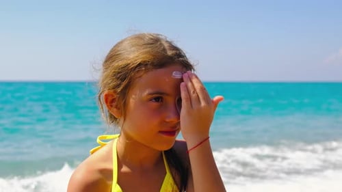 The Child Puts Sunscreen on Her Face