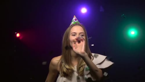 Girl Blows Off Confetti, Blowing Party Whistle. Close-up. Slow Motion