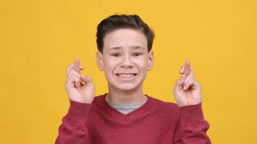 Smiling Teen Crossing Fingers Wishing for Good Luck