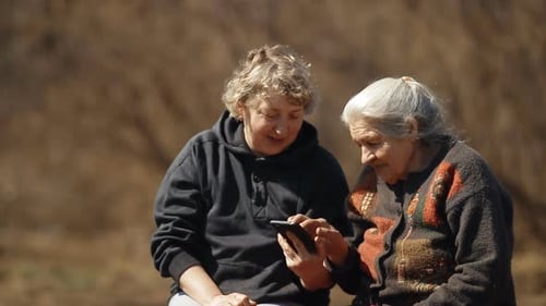 Woman and Senior looking at Mobile Phone