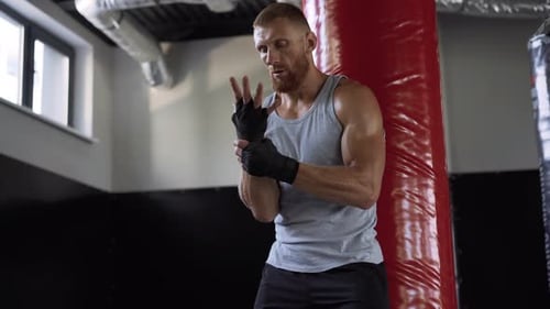 Muscular Man Wrapping Hands in Gym