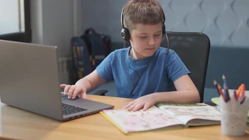 Focused Child Studies Online at Home with Laptop
