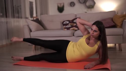 Woman Lying on Mat Doing Leg Lifts
