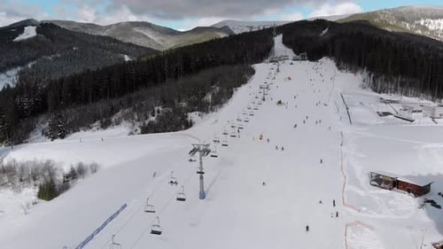 Aerial Ski Slopes with Skiers and Ski Lifts on Ski Resort in Snowy Mountains