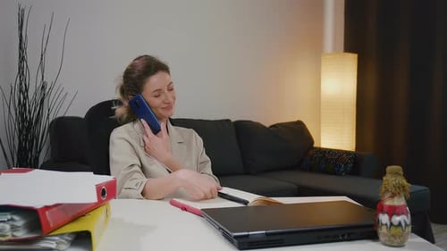 Woman Talking on Cell Phone at Desk