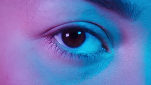 Nahaufnahme des schönen braunen Auges einer jungen Frau, die blinzelt, die Augen schließt und öffnet und direkt hineinschaut